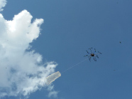 Octocopter in der Luft vor weiß-blauem Himmel