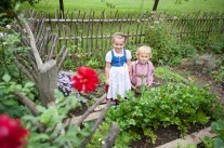 Junge und Mädchen in Tracht im Gemüsebeet