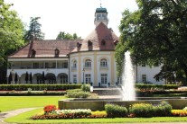 Springbrunnen mit Blumenrabatte, im Hintergrund das historische Kurhaus