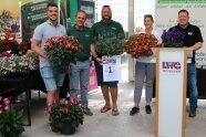 Fünf Gewinner mit ihren eigenen Blumen in der Hand haltend.