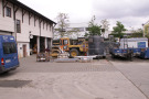 Blick in den Betriebshof eines GaLabBu-Unternehmens mit Fuhrpark und Materialpaletten.
