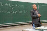 Markus Schaller steht in einem Hörsaal vor einer grünen Tafel.