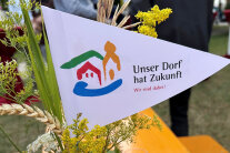 Eine Fahne auf der Unser Dorf hat Zukunft steht.