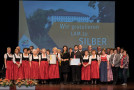 Gruppenbild der Silbergewinner aus Lam auf der Bühne mit Staatsministerin Michaela Kaniber