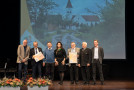Gruppenbild der Bronzegewinner aus Ursensollen auf der Bühne mit Staatsministerin Michaela Kaniber