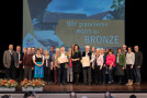 Gruppenbild der Bronzegewinner aus Moos auf der Bühne mit Staatsministerin Michaela Kaniber