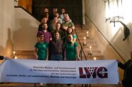 Klasse steht mit Schulbanner auf der Kellertreppe im Zehntkeller der LWG