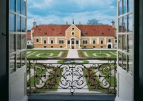 Blick aus dem geöffneten Fenster über die bepflanzten Parterre 