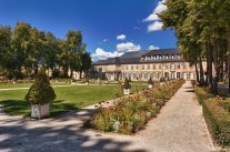 Blick über Beete und Rasenflächen mit Pflanzenkübeln auf das Neue Schloss Bayreuth