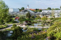 Blick über Teichlandschaft mit Brücken auf Gewächshäuser