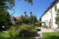 Erhöhte Kräuterbeete mit Steinumrandung vor dem Kloster