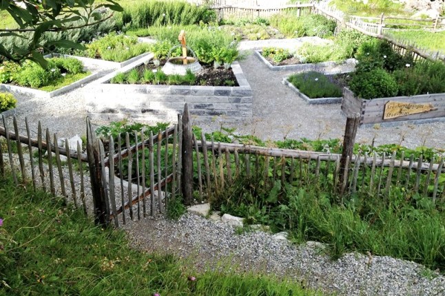 Am Hang gelegener Kräutergarten mit verschiedenen Beeten