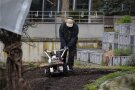 Mann fräst Gartenboden