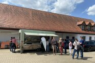 Teilnehmer stehen am Foodtruck in der Mittagspause.