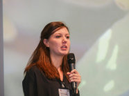 Julia Grauberger mit Mikrofon in der Hand auf der Bühne.