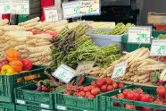 Am Marktstand mit Spargel, Tomaten, Paprika in einer Kiste und Preisschildern