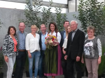 Frau Kaniber mit Blumenstrauß in der Hand mit Familie Wohlhüter