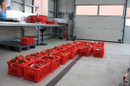 Rote Kisten mit Tomaten auf den Boden aufgereiht