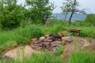 Eine Kombination aus Sandhaufen, Steinhaufen und verschiedenen Hölzern, die aufgeschichtet wurden, um Lebensräume für Tiere zu schaffen. Biodiversitätsfläche auf Streuobstwiese dient als Unterschlupf für viele Nützlinge und fördert die Artenvielfalt.