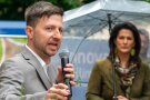 Florian Demling am Mikrofon, Michaela Kaniber im Hintergrund mit Regenschirm