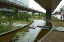 Ein mit Regenwasser gespeister künstlicher Bachlauf unter einer Straßenbrücke in Kopenhagen. 