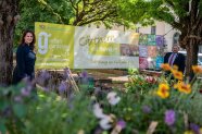 eine Frau und ein Mann stehen an einem Banner zum Urban Gardening in München