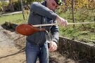 Mit einer besonderen Technik wird aus einem tönernen Gefäß an langem Holzstab Wein ins Glas gegossen.