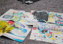 Bunte Skizzen auf Papier die auf dem abgedeckten Boden liegen